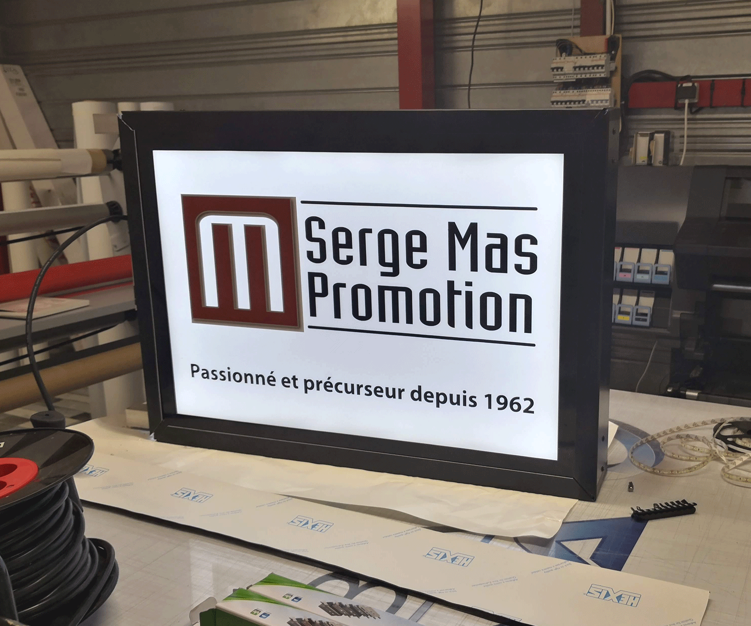 Enseigne lumineuse de type caisson noir affichant le logo et le texte "Serge Mas Promotion - Passionné et précurseur depuis 1962", produit par Global Signa France à Toulouse.