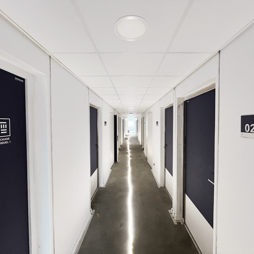 Couloir avec une signalétique murale pour identifier les chambres.